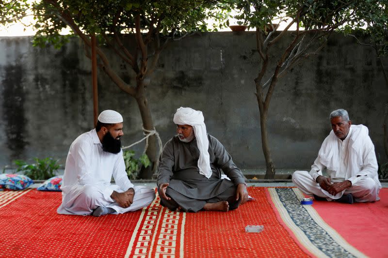 Dilawar Khan, father of Muhammad Ali, sits with people who came to attend prayer after his son's funeral in Bhojpur town in Gujrat