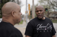 Kansas City, Kan. mayor Tyrone Garner talks to barber David Grisby while helping volunteers clean a neighboring park Friday, April 22, 2022, in Kansas City, Kan. Garner was elected in last November becoming the city's first Black mayor and has created a committee that would propose police reforms. (AP Photo/Charlie Riedel)