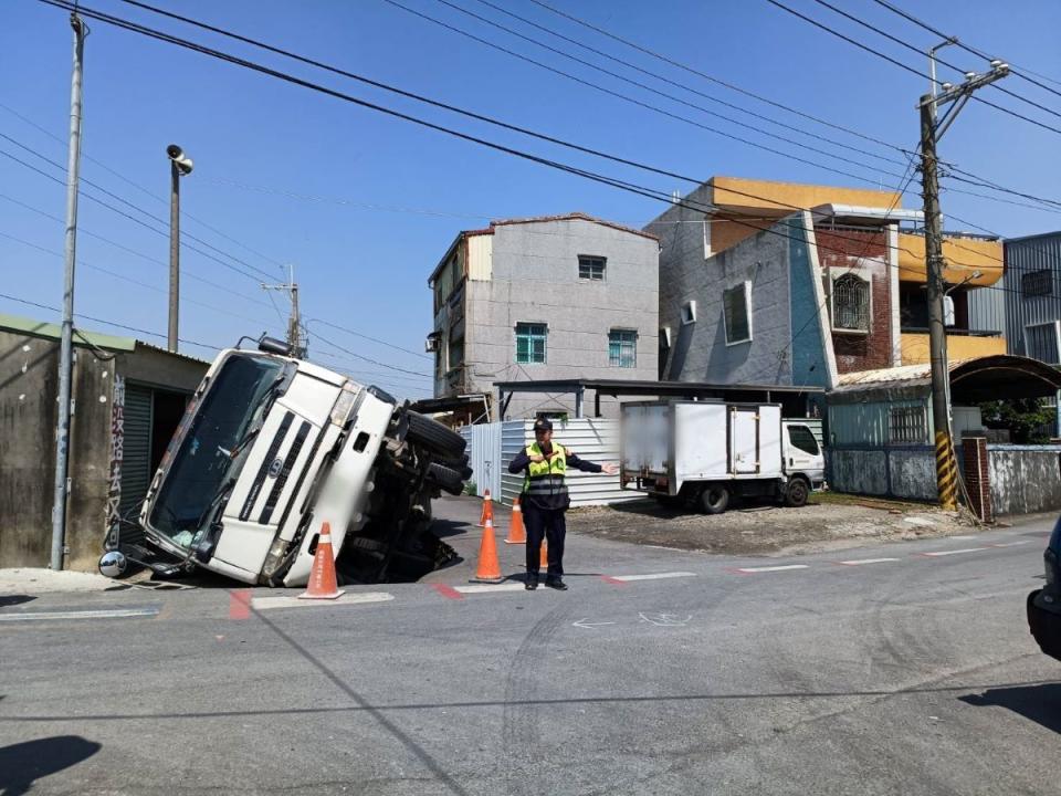 一輛預拌混凝土車今天上午行經高雄市路竹區成功路223巷口倒車時，路面突然塌陷，導致混凝土車往右傾倒。（圖：湖內分局提供）