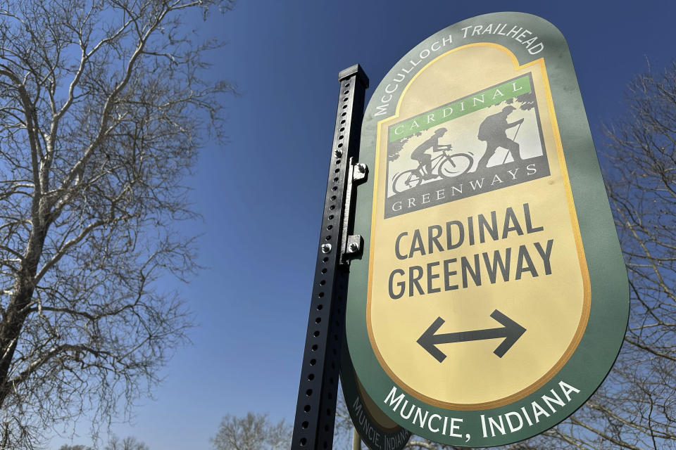 A sign in Muncie, Ind. directs users on the Cardinal Greenways pathway Wednesday, March 13, 2024. Born from eastern Indiana's abandoned railroad tracks, the Cardinal Greenways pathway will become a central cog in the Great American Rail Trail — a planned 3,700-mile network of uninterrupted trails spanning from Washington state to Washington, D.C. (AP Photo/Isabella Volmert)