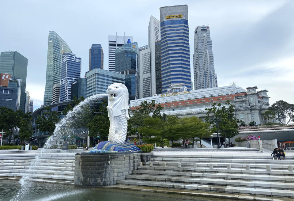 A couple sits near the Merlion statue, a popular tourist landmark, in Singapore Monday, May 31, 2021. Singapore's Prime Minister Lee Hsien Loong said Monday that controls to lower coronavirus infections were working, while announcing a move to vaccinate students after a spate of transmissions in schools and learning centers. (AP Photo/Annabelle Liang)