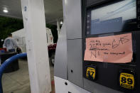 A hand written sign is posted on a gas pump, showing that the service station is out of all grades of fuel Wednesday, May 12, 2021, in Charlotte, N.C. Several gas stations in the Southeast reported running out of fuel, primarily because of what analysts say is unwarranted panic-buying among drivers, as the shutdown of a major pipeline by hackers entered its fifth day. (AP Photo/Chris Carlson)