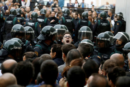 Scuffles break out as Spanish Civil Guard officers force their way through a crowd and into a polling station for the banned independence referendum where Catalan President Carles Puigdemont was supposed to vote in Sant Julia de Ramis. REUTERS/Juan Medina