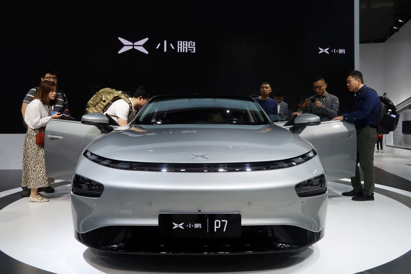 FILE PHOTO: People look at XPeng's P7 sedan model displayed at the Guangzhou auto show in Guangzhou