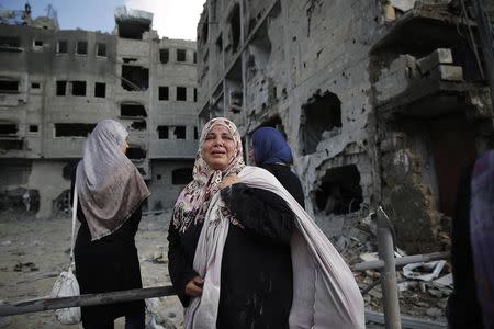 A Palestinian woman weeps as she stands amid destroyed buildings in Beit Hanoun town, which witnesses said was heavily hit by Israeli shelling and air strikes during an Israeli offensive, in the northern Gaza Strip July 26, 2014. REUTERS/Finbarr O'Reilly