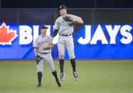 Mar 29, 2018; Toronto, Ontario, CAN; New York Yankees right fielder Aaron Judge (99) celebrates the win with New York Yankees left fielder Brett Gardner (11) at the end of the Toronto Blue Jays home opener at Rogers Centre. The New York Yankees won 6-1. Mandatory Credit: Nick Turchiaro-USA TODAY Sports