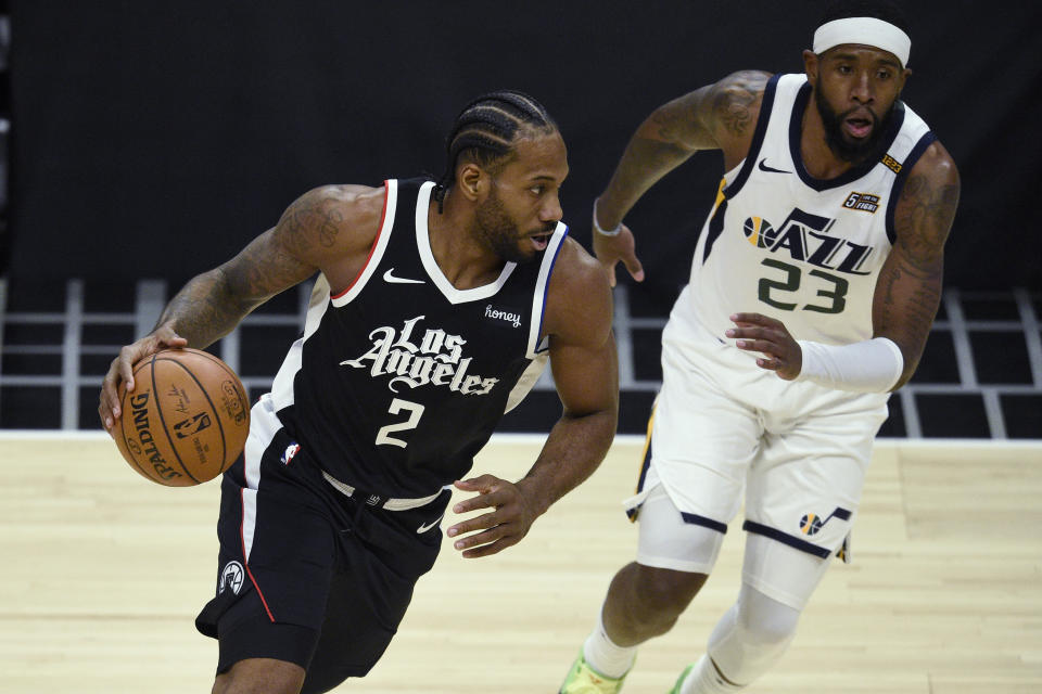 Los Angeles Clippers forward Kawhi Leonard, left, is defended by Utah Jazz forward Royce O'Neale during the first half of an NBA basketball game in Los Angeles, Friday, Feb. 19, 2021. (AP Photo/Kelvin Kuo)