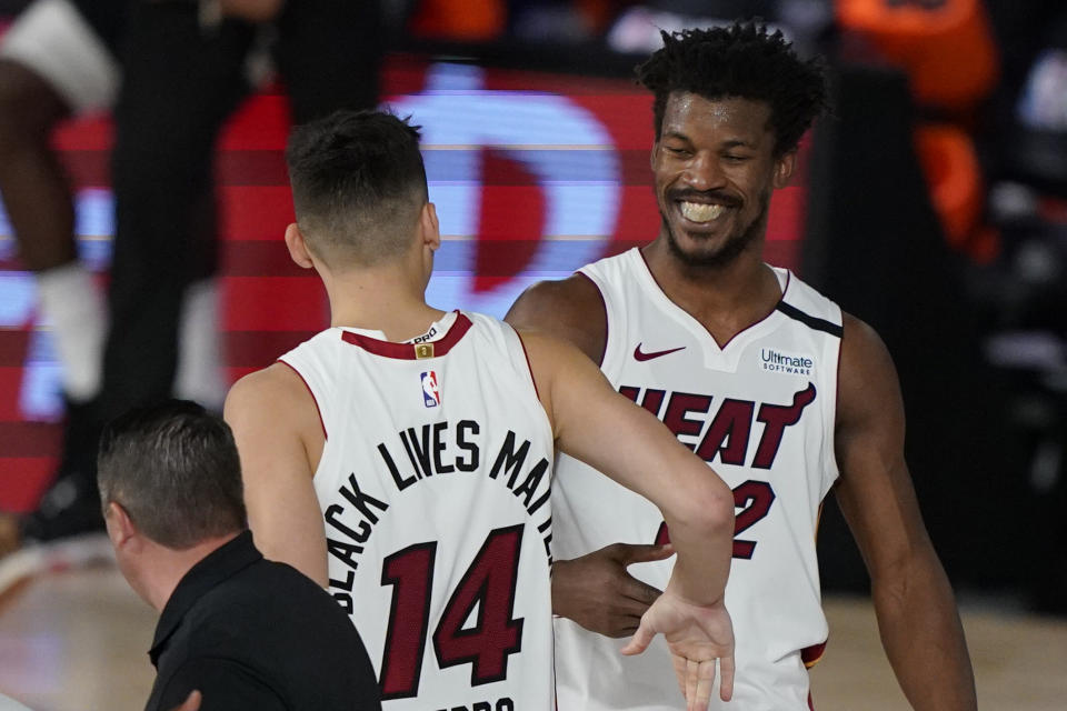 Miami Heat's Tyler Herro (14) and Jimmy Butler (22) react after the Heat beat the Milwaukee Bucks 116-114 in an NBA conference semifinal playoff basketball game Wednesday, Sept. 2, 2020, in Lake Buena Vista, Fla. (AP Photo/Mark J. Terrill)