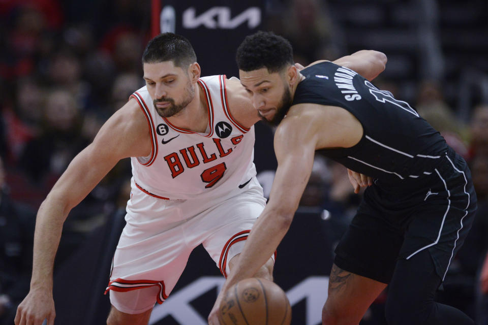 Brooklyn Nets' Ben Simmons (10) reaches for the ball next to Chicago Bulls' Nikola Vucevic (9) during the first half of an NBA basketball game Wednesday, Jan. 4, 2023, in Chicago. (AP Photo/Paul Beaty)