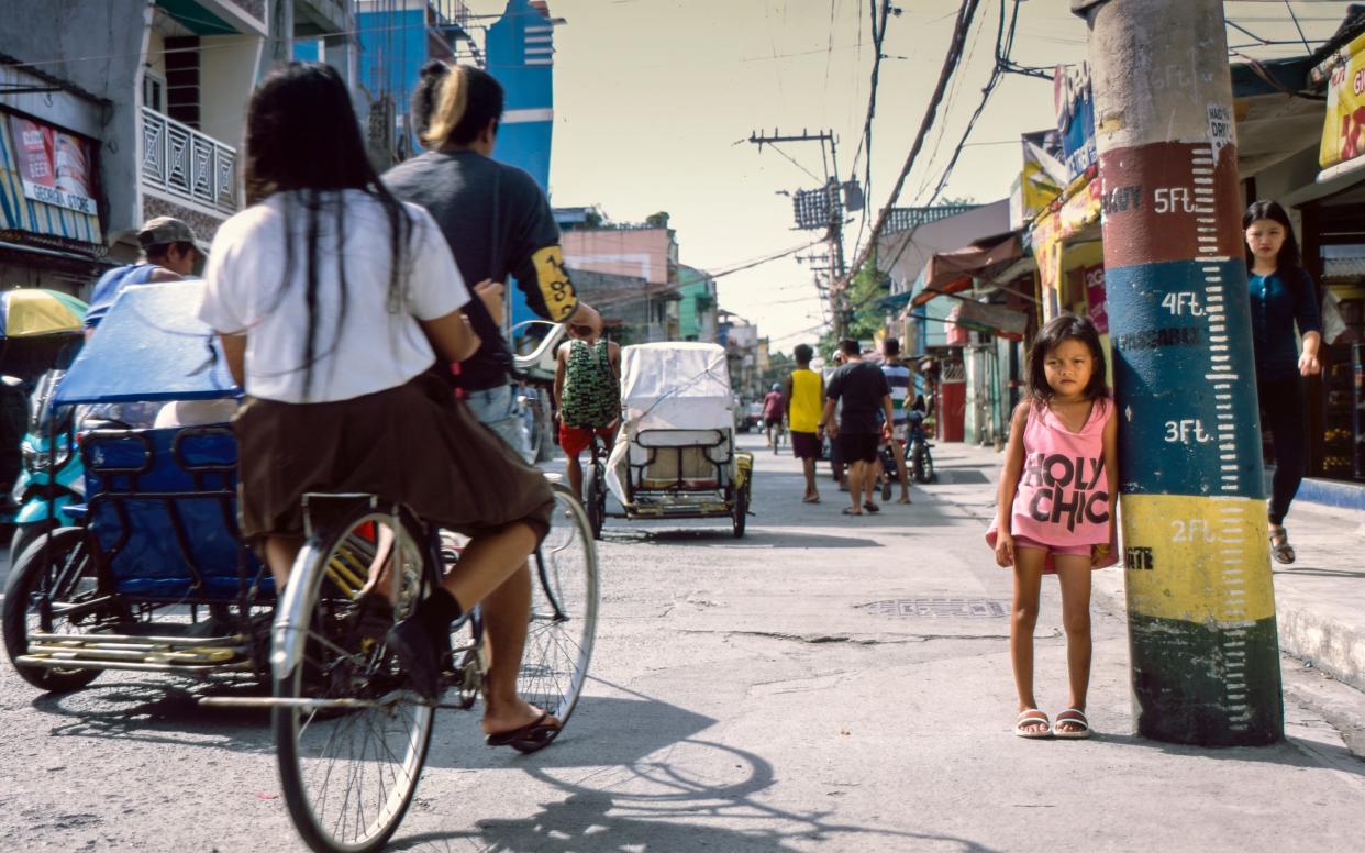 Ashlie Arangues, aged 13, stands next to a flood measurement barrier on Metro Manila's North Bay Boulevard, in Navotas City. She is severely stunted and is the same size as child half her age. - © 2018 Simon Townsley Ltd