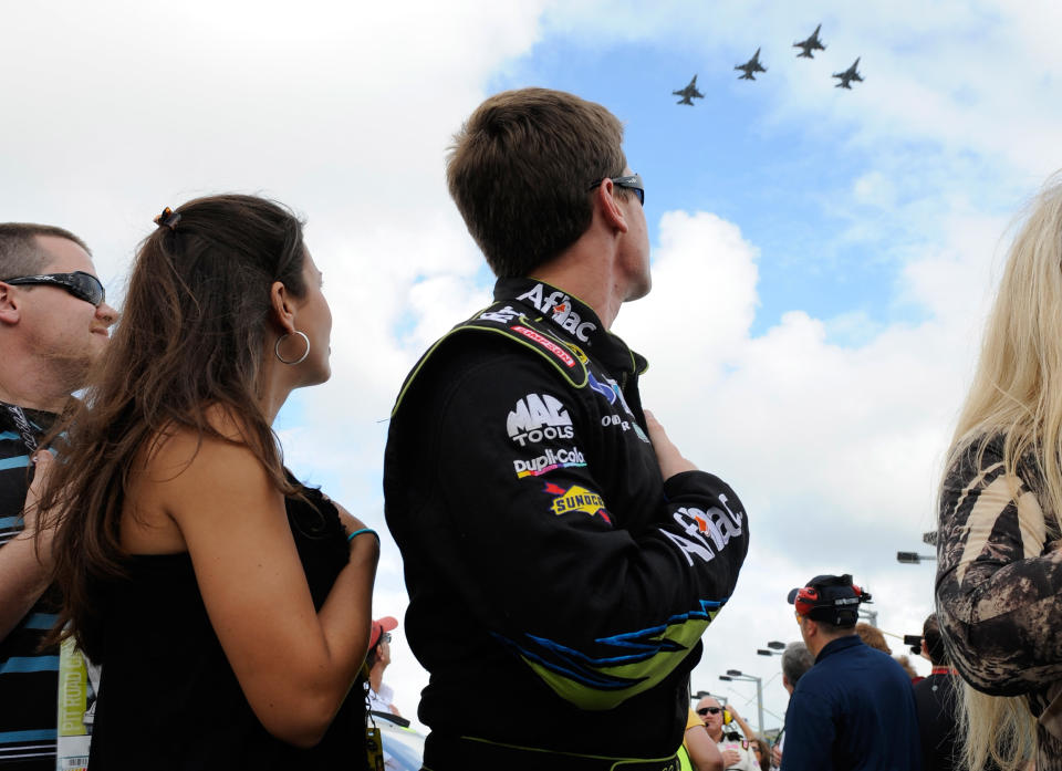 HOMESTEAD, FL - NOVEMBER 20: Carl Edwards, driver of the #99 Aflac Ford, and wife Kate Edwards watch a fly over during the singing of the national anthem as they stand next to his car on the grid before the NASCAR Sprint Cup Series Ford 400 at Homestead-Miami Speedway on November 20, 2011 in Homestead, Florida. (Photo by Jared C. Tilton/Getty Images)