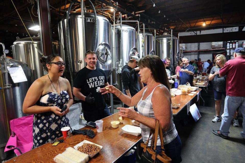 Clea Godsey chatted with fellow Indianan Nancy Adams, visiting from LaPorte, as she samples Pelgenius beer cheese, made by Jonathan Pelgen of Georgetown, during Country Boy Brewing’s fourth annual beer cheese contest on Sunday in Lexington. This year will be the seventh annual competition on May 21.