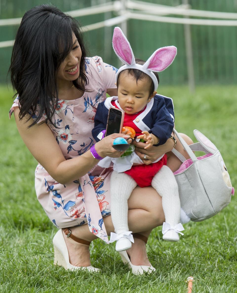 Cynthia Cheng of San Francisco helps her daughter, 11-month-old Victoria, participate in an Easter egg roll race.