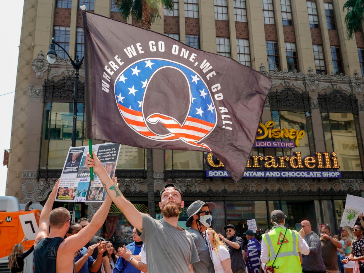 <p>Conspiracy theorist QAnon demonstrators protest child trafficking on Hollywood Boulevard in Los Angeles, California, on 22 August 2020</p> ((AFP via Getty Images))