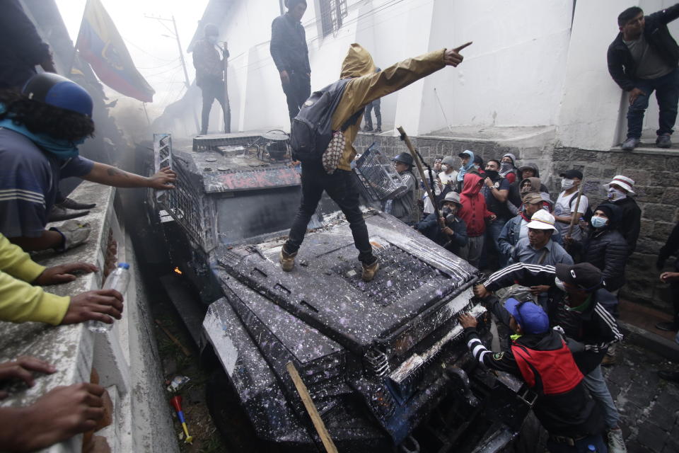 FILE - In this Oct. 9, 2019, file photo, anti-government demonstrators commandeer an armored vehicle during a nationwide strike against President Lenin Moreno and his economic policies in Quito, Ecuador. From Honduras to Chile, popular frustration with anemic economic growth, entrenched corruption and gaping inequality is driving the region’s middle classes to rebel against incumbents of all ideological bents in what has been dubbed by some the Latin American Spring. (AP Photo/Carlos Noriega, File)