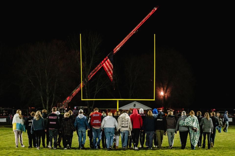Students walk on the football field during a community prayer vigil, Tuesday, Nov. 14, 2023, at the Tuscarawas Valley Schools football stadium in Zoarville, Ohio. (Andrew Dolph/Times Reporter via AP)