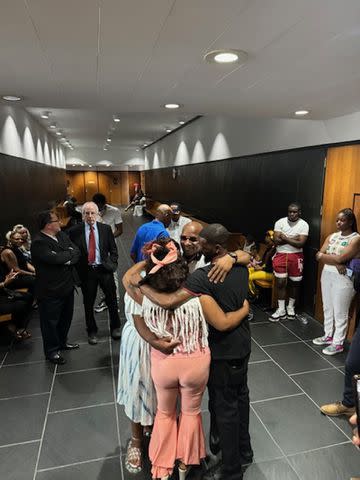<p>Shereef Akeel</p> After learning his case will not be retried, Paul Clark, Jr. celebrated with a family group hug outside Michigan's 3rd Circuit Court, Tuesday, July 23.