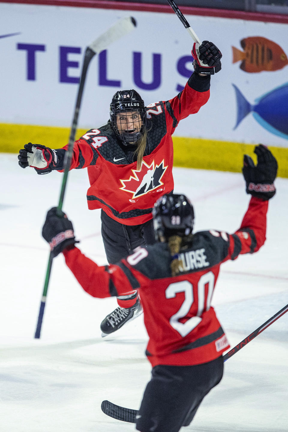 Canada's Natalie Spooner (24) and Sarah Nurse (20) celebrate a goal against the United States during the third period of a Rivalry Series hockey game Friday, Feb. 9, 2024, in Regina, Saskatchewan. (Liam Richards/The Canadian Press via AP)