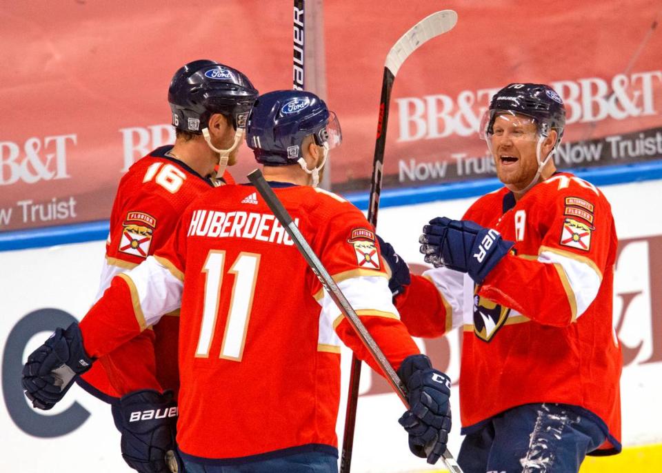 Florida Panthers left wing Jonathan Huberdeau (11) is congratulated by teammates Aleksander Barkov (16) Patric Hornqvist (70) after scoring against the Chicago Blackhawks during the third period of the Florida Panthers NHL home opener game at the BB&T Center on Sunday, January 17, 2021 in Sunrise, Fl.