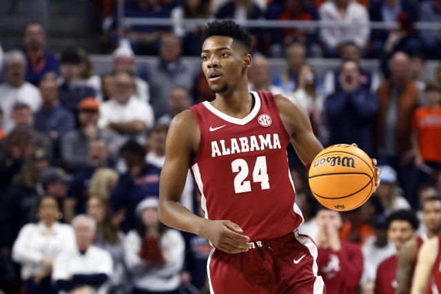 FILE - Alabama forward Brandon Miller brings the ball up during the first half of the team's NCAA college basketball game against Auburn on Feb. 11, 2023, in Auburn, Ala. At Alabama, one of the team's best players is connected to a killing for allegedly delivering a gun to a murder suspect. An Associated Press analysis of more than a dozen schools in the NCAA tournaments shows a wide range of policies that govern guns at those schools and uneven efforts to regulate them. (AP Photo/Butch Dill, File)