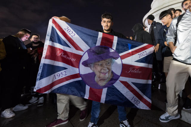 Un hombre despliega una bandera británica con la imagen de la reina Isabel II el día de su muerte.