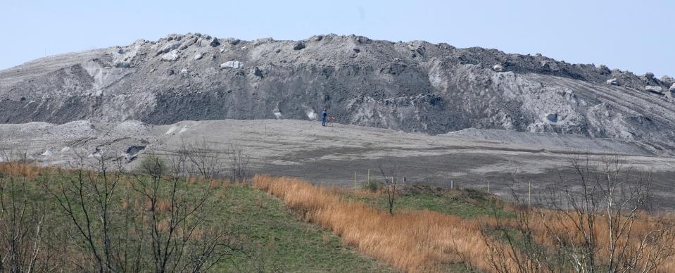 A huge landfill comprised of coal ash and scrubber sludge  occupies a valley near the James M. Gavin coal-fired power plant in Gallia County in this 2008 file photo. The American Electric Power facility uses a conveyor belt to bring the waste to this landfill and then uses trucks and dozers to spread it.