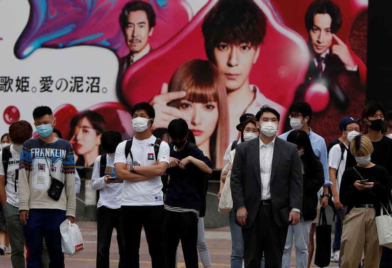 Passersby wearing protective face masks are seen as the spread of the coronavirus disease (COVID-19) continues, in Tokyo