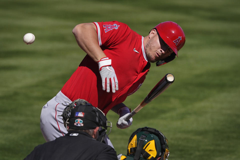 Mike Trout de los Angelinos de Los Ángeles recibe un pelotazo durante el juego de pretemporada contra los Atléticos de Oakland, el viernes 5 de marzo de 2021, en Mesa, Arizona. (AP Foto/Matt York)