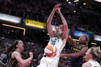 New York Liberty forward Breanna Stewart (30) fights for a loose ball with Indiana Fever guard Caitlin Clark, left, and forward Aliyah Boston in the first half of a WNBA basketball game, Thursday, May 16, 2024, in Indianapolis. (AP Photo/Michael Conroy)