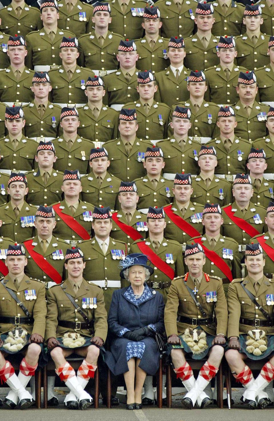 Queen Elizabeth II poses for a picture with members of the 1st Battalion of the Argyll and Sutherland Highlanders at Howe Barracks in Canterbury, 2004 (AFP via Getty)