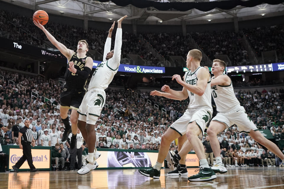 Purdue guard Braden Smith (3) makes a layup as Michigan State guard Tre Holloman (5) defends during the first half of an NCAA college basketball game, Monday, Jan. 16, 2023, in East Lansing, Mich. (AP Photo/Carlos Osorio)