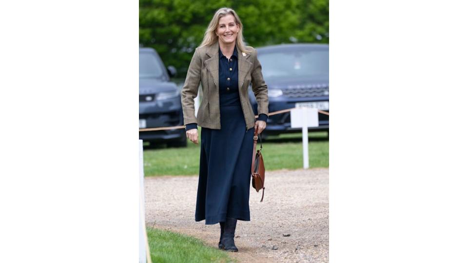 Duchess Sophie walking in navy dress with tan Isabel Marant bag