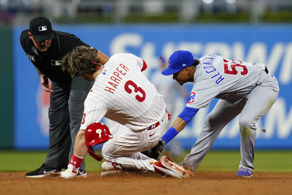 Philadelphia Phillies' Bryce Harper, center, slides into second for an RBI-double past the tag from Chicago Cubs shortstop Sergio Alcantara, right, during the sixth inning of a baseball game, Tuesday, Sept. 14, 2021, in Philadelphia. (AP Photo/Matt Slocum)