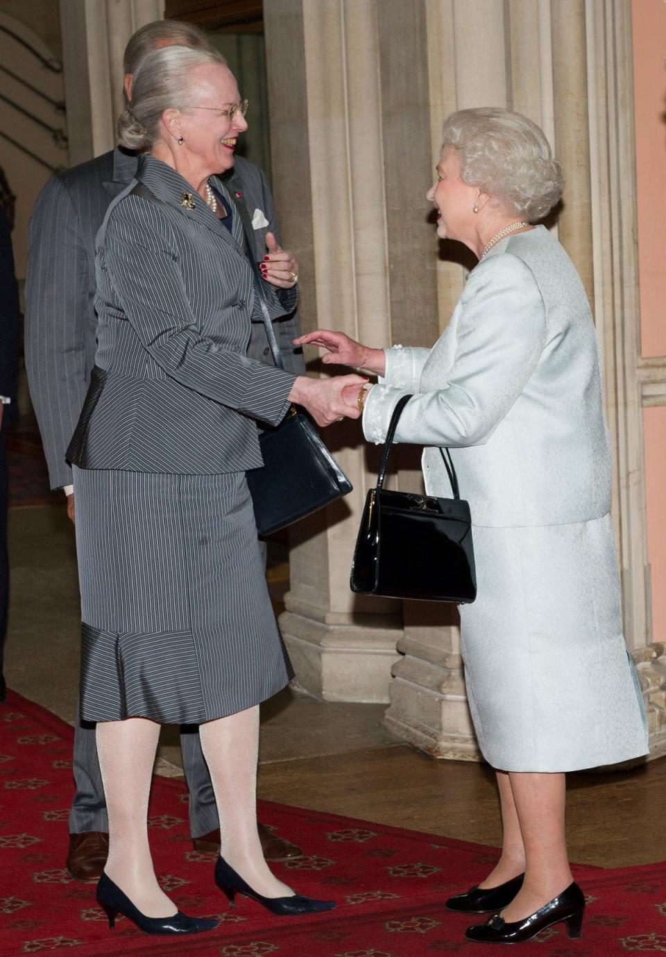 La reina Isabel II derecha da la bienvenida a la reina Margarita II de Dinamarca al Castillo de Windsor, el 18 de mayo de 2012 (AFP via Getty Images)