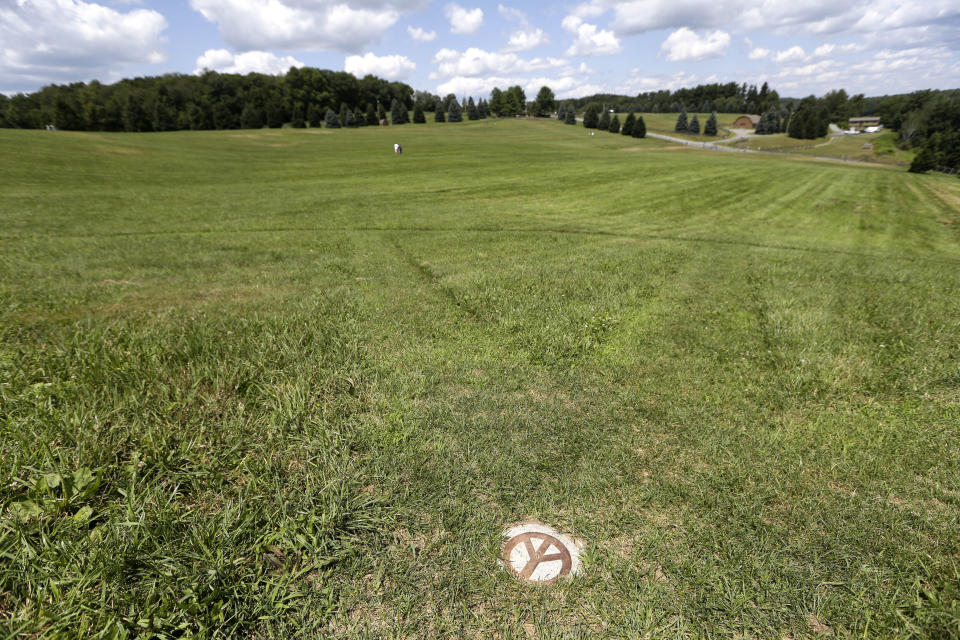 A small peace sign is set into the grass at the site of the 1969 Woodstock Music and Arts Fair, Wednesday, July 24, 2019 in Bethel, N.Y. Woodstock will be celebrated on its 50th anniversary, but it won't be your hippie uncle's trample-the-fences concert. While plans for a big Woodstock 50 festival collapsed after a run of calamities, the bucolic upstate New York site of the 1969 show is hosting a long weekend of events featuring separate shows by festival veterans like Carlos Santana and John Fogerty. (AP Photo/Seth Wenig)