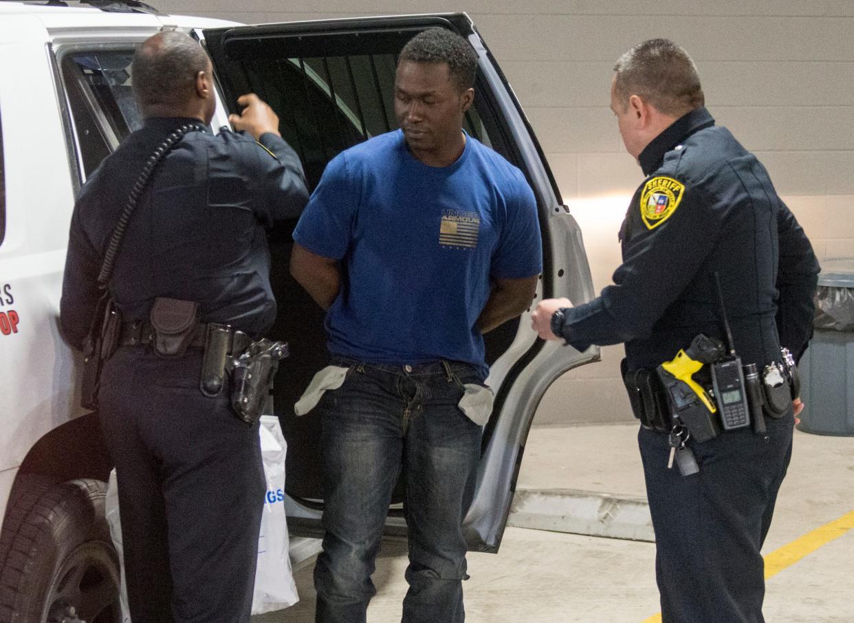 In this March 3, 2019, file photo,  Air Force Maj. Andre McDonald, center, is escorted to the Bexar County Magistrate center in San Antonio.