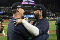 Seattle Mariners manager Scott Servais, left, and Eugenio Suarez embrace after the team's baseball game against the Oakland Athletics, Friday, Sept. 30, 2022, in Seattle. The Mariners won 2-1 to clinch a spot in the playoffs. (AP Photo/Stephen Brashear)