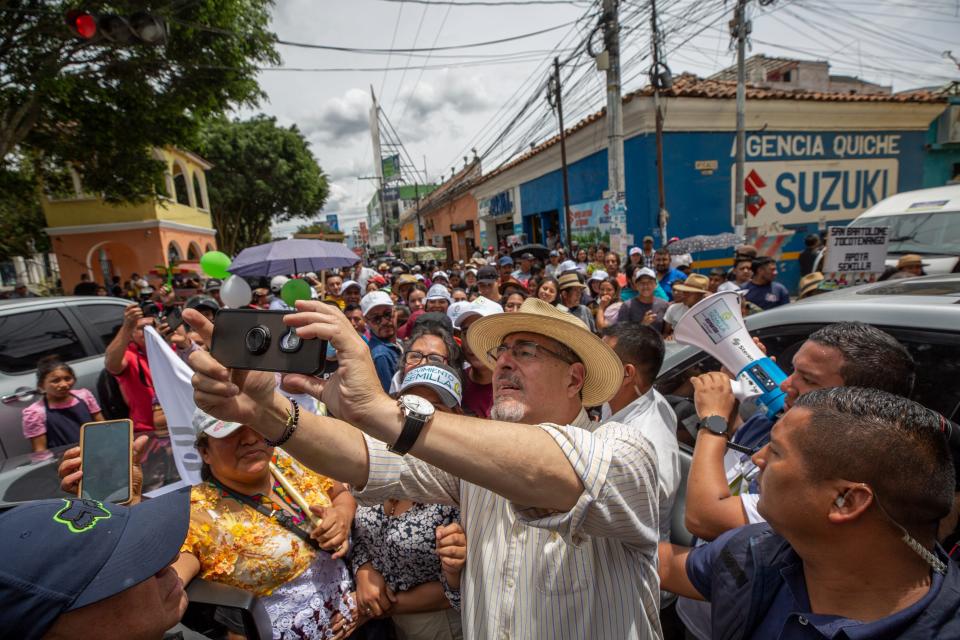 Presidential candidate Bernardo Arevalo takes selfies with his supporters in the central square of Santa Cruz del Quiche, Guatemala on Aug.11, 2023, after a political rally.