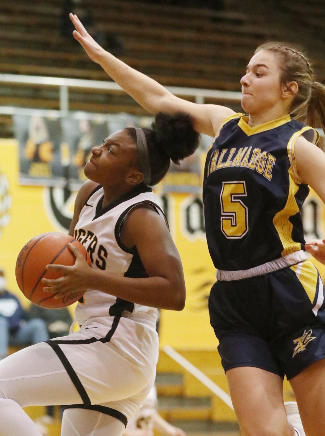 Cuyahoga Falls' Darlene Smith goes to the hoop as  Tallmadge's Jadyn Harjung defends during the Suburban League game at Cuyahoga Falls High School.