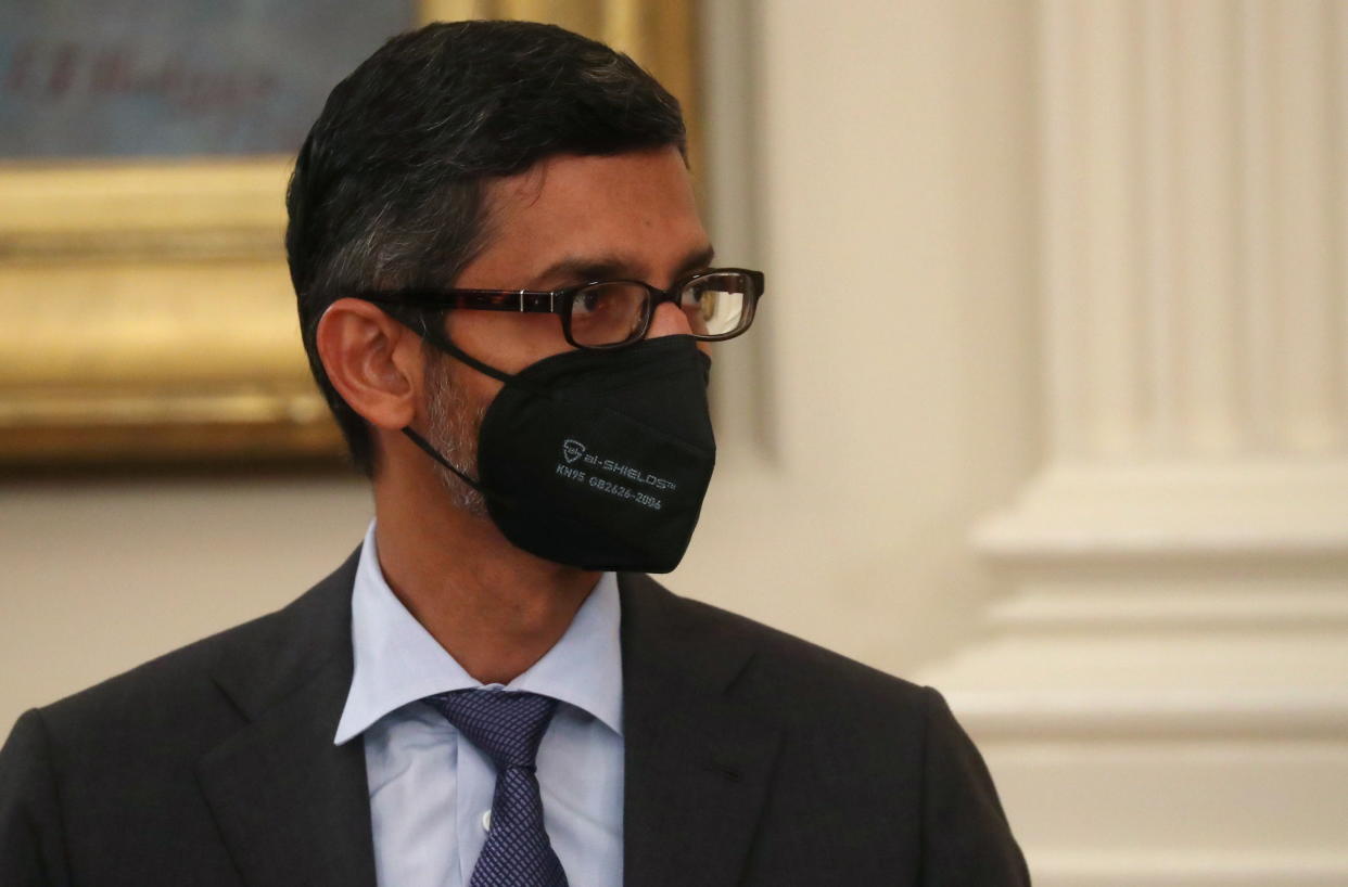 Sundar Pichai, CEO of Alphabet, wearing a mask and listening as U.S. President Joe Biden delivers remarks