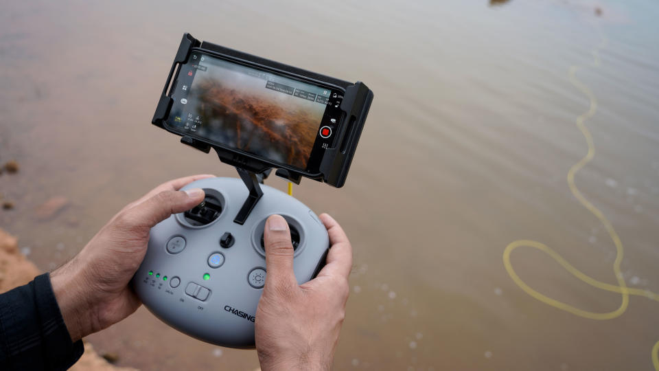 Chasing M2S Underwater Drone or ROV controller in hand with yellow control cable visible in water below