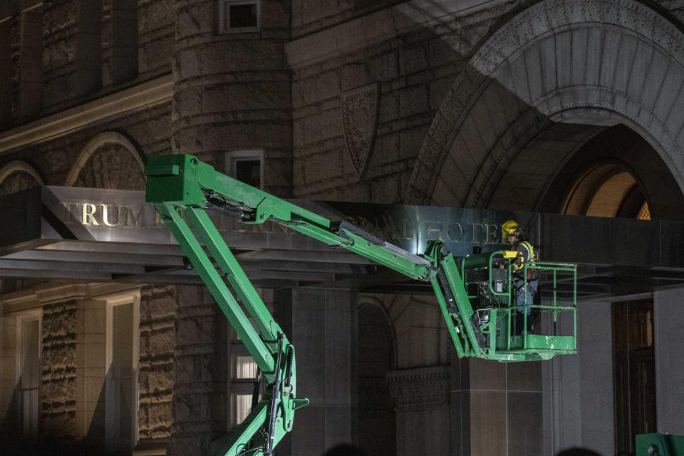 A worker removes the signage for the Trump International Hotel Wednesday, May 11, 2022, in Washington. The lease to the Washington hotel run by Donald Trump's family company while he was president, has been sold by his family company to a Miami-based investor fund. (AP Photo/Gemunu Amarasinghe)