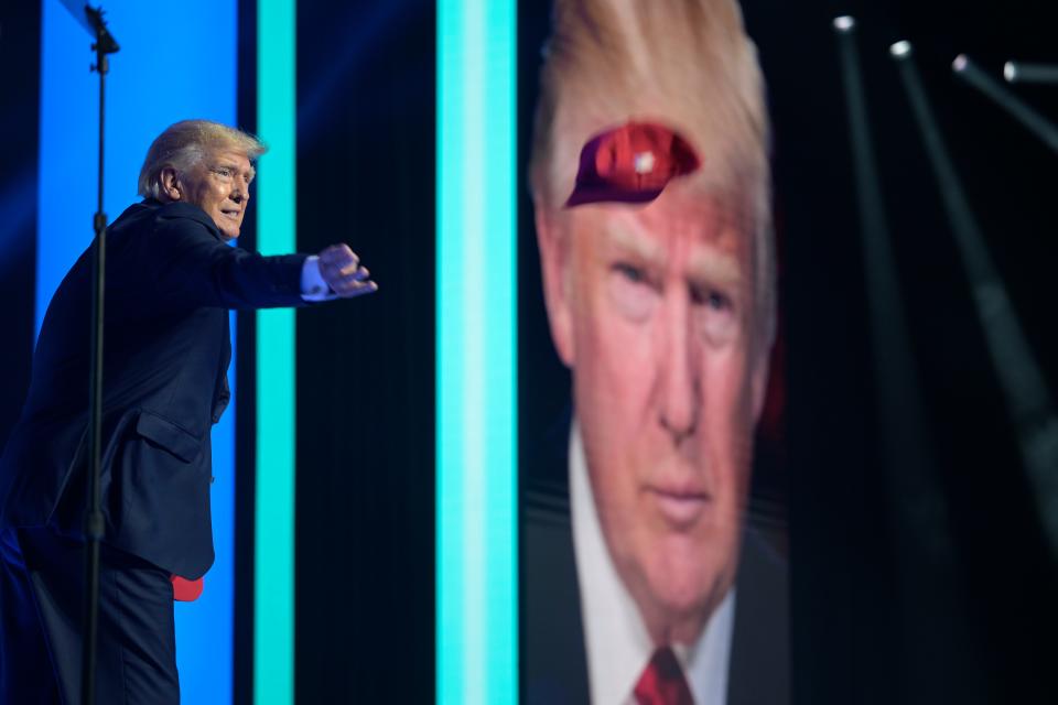 Former President Donald Trump tosses hats into the crowd before addressing attendees during the Turning Point USA Student Action Summit, Saturday, July 23, 2022, in Tampa, Fla. (AP Photo/Phelan M. Ebenhack)