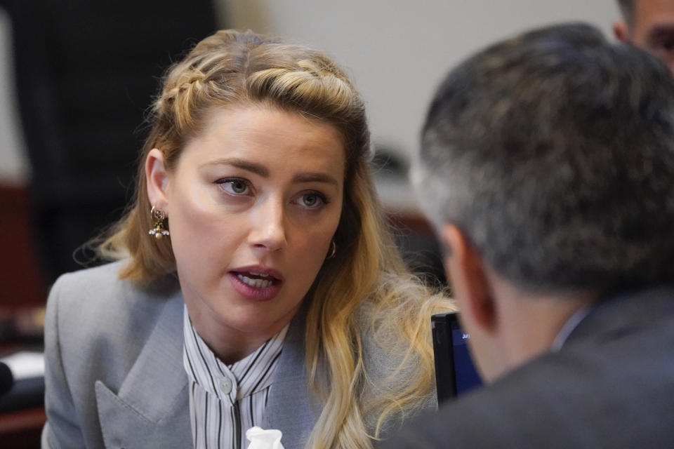 Actor Amber Heard speaks to her legal team in the courtroom at the Fairfax County Circuit Courthouse in Fairfax, Va., Friday, May 27, 2022. Actor Johnny Depp sued his ex-wife Amber Heard for libel in Fairfax County Circuit Court after she wrote an op-ed piece in The Washington Post in 2018 referring to herself as a "public figure representing domestic abuse." (AP Photo/Steve Helber, Pool)