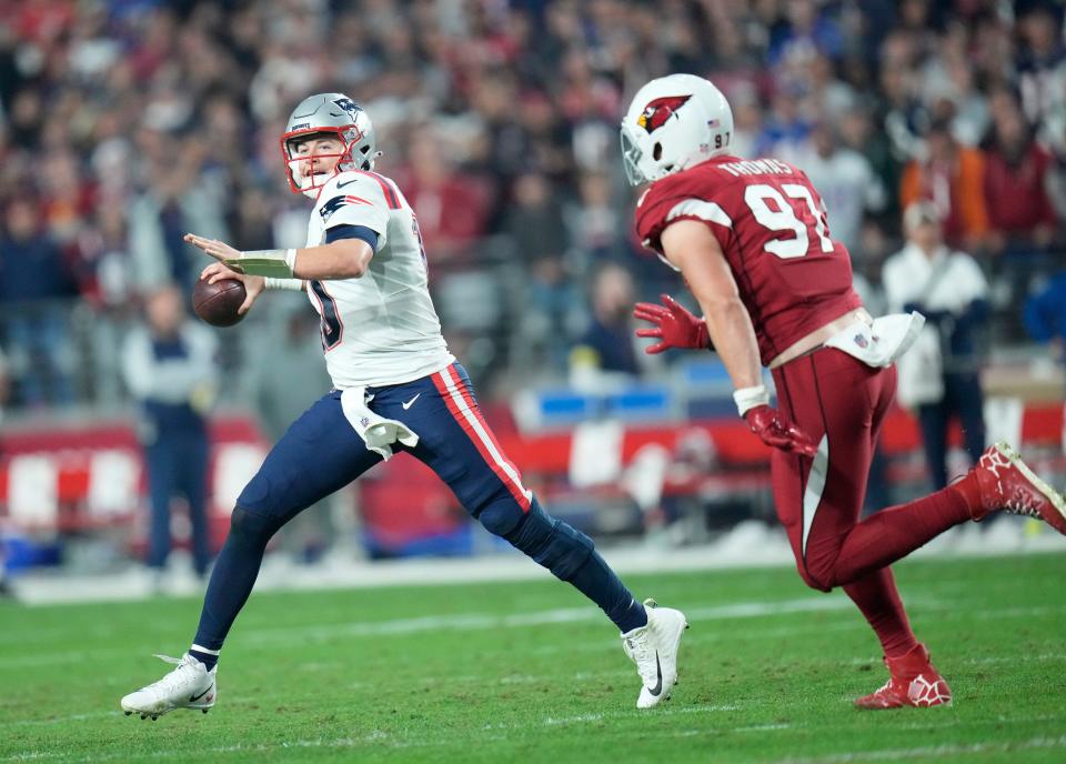 Dec 12, 2022; Glendale, Ariz., USA;  New England Patriots quarterback Mac Jones (10) throws the ball while pressured by Arizona Cardinals linebacker Cameron Thomas (97) during the third quarter at State Farm Stadium.