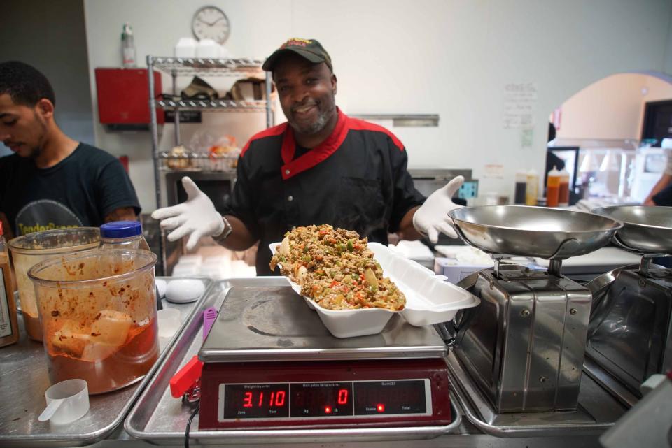 Clint "Chef Bones" Harris weighs his 3-pound "Chef Philly Cheesesteak" sandwich at his TenderBones Rib Shack near Bear.