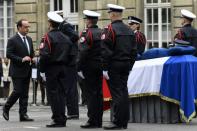 French President Francois Hollande posthumously awards Xavier Jugele, the policeman killed by a jihadist in an attack on the Champs Elysees, during a ceremony on April 25, 2017 at the Paris prefecture building