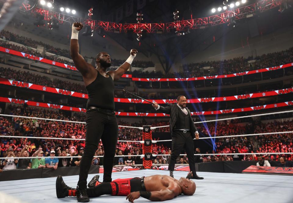 MVP points to his new prodigy, the 7-foot-4-inch Nigerian Giant Omos during a RAW event.