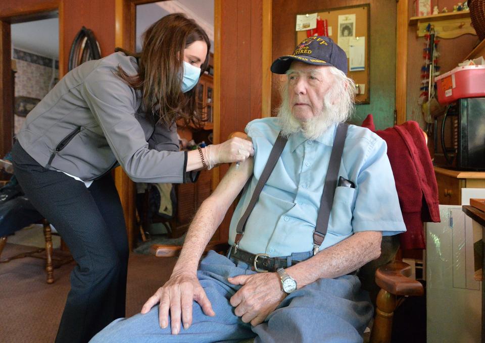 Jaime Babiak, left, pharmacy director for the LECOM Institute for Successful Aging, gives the COVID-19 vaccine to Albert Hunter, 88, during a mobile COVID-19 vaccination program on April 23 in Mill Village. Babiak, 36, helps administer the vaccine to homebound patients, many of whom have medical conditions that prevent them from leaving their residences.