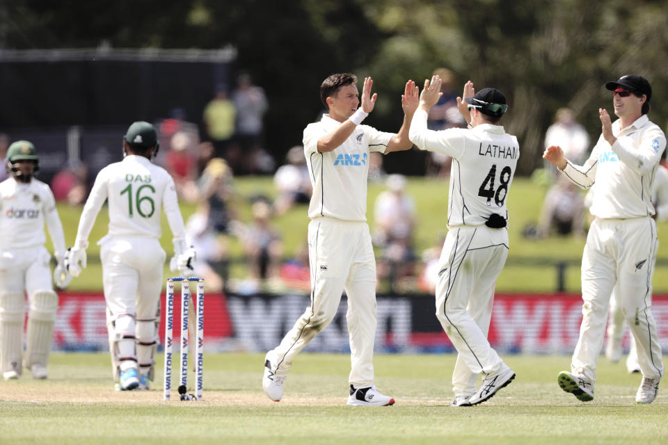 Trent Boult of New Zealand celebrates with Tom Latham during play on day three of the second cricket test between Bangladesh and New Zealand at Hagley Oval in Christchurch, New Zealand, Tuesday, Jan. 11, 2022. (Martin Hunter/Photosport via AP)